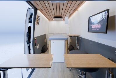 Training table and wall-mounted screen inside a mobile medical simulator